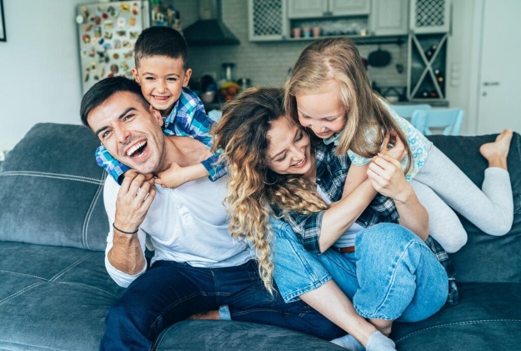 Family on couch with kids laughing